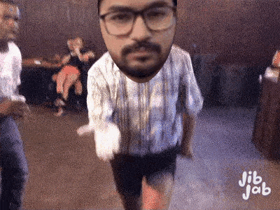 a man with glasses and a beard is dancing in a room with people .