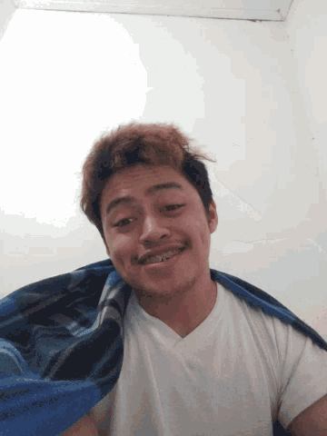 a man with a towel on his shoulder is smiling