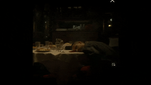 a person is sleeping at a table with a light shining on it .