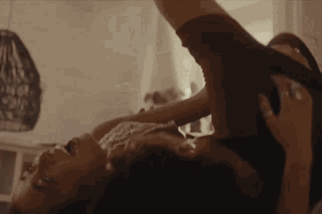 a man and a woman are laying on their backs on a bed with their arms outstretched .