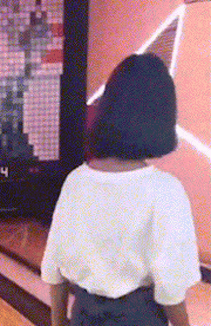 a woman in a white shirt is standing in front of a screen that says n on it