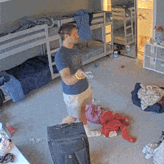 a man is standing in a messy room with bunk beds