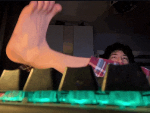 a person 's foot is sticking out of the keyboard