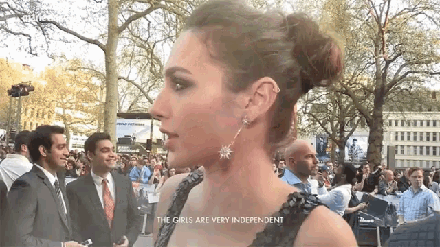 a woman stands in front of a crowd with the words " the girls are very independent " above her