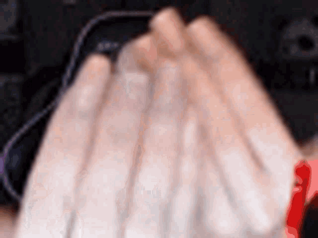 a close up of a person 's hand with a red ribbon on it .