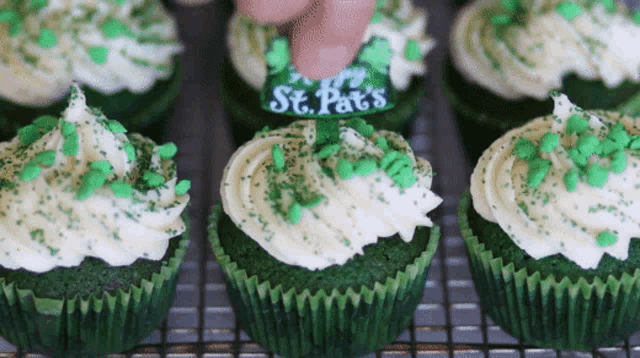 a cupcake with green frosting and sprinkles says st. pats