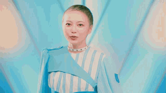a woman wearing a blue and white striped dress is pointing up
