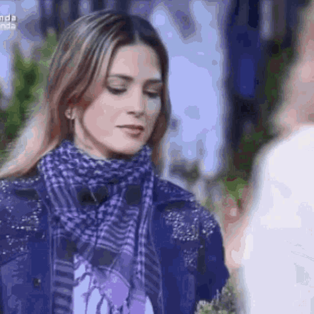 a woman wearing a purple scarf and a purple jacket