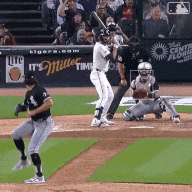 a baseball game is being played in front of a miller lite banner