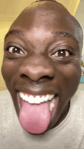 a close up of a man 's face with his tongue hanging out