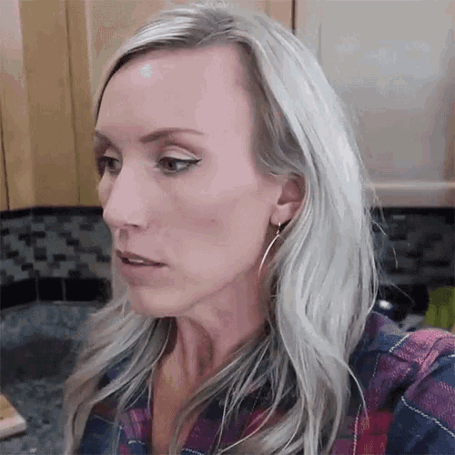 a woman in a plaid shirt is wearing earrings
