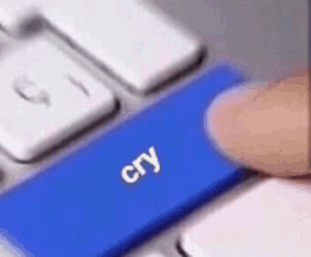 a person is pressing a blue cry button on a computer keyboard .