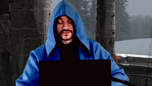 a man in a blue hooded jacket is using a laptop