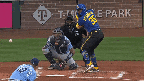 a baseball player with the number 35 on his back is about to hit the ball