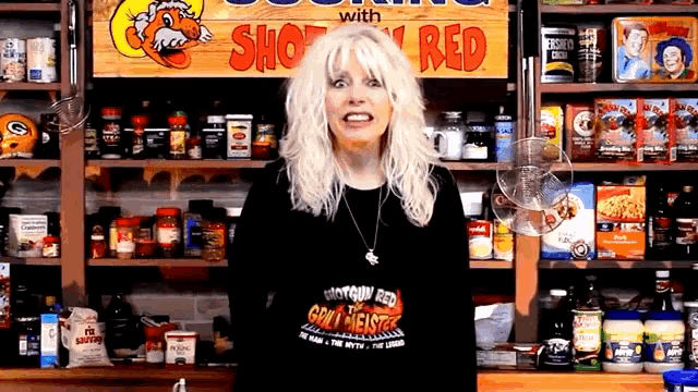 a woman stands in front of a sign that says " shop red "
