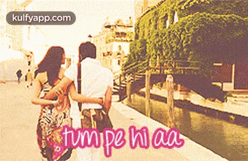 a couple walking down a street with the words tum pe hi aa written in pink
