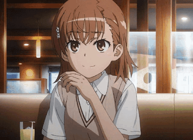 a girl with brown hair is sitting in a cafe