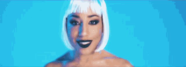 a woman in a white wig is applying makeup to her face with a brush