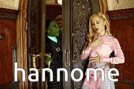 a woman in a pink shirt is standing in front of a door with the word hannome written in white letters