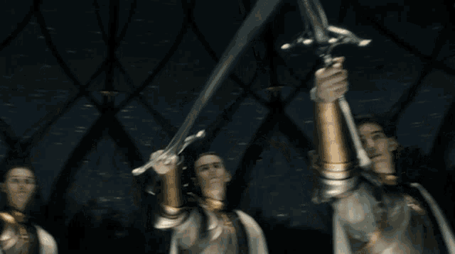 two men in armor are holding swords in their hands