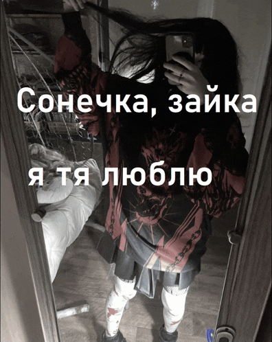 a girl is taking a picture of herself in a mirror with russian writing on it