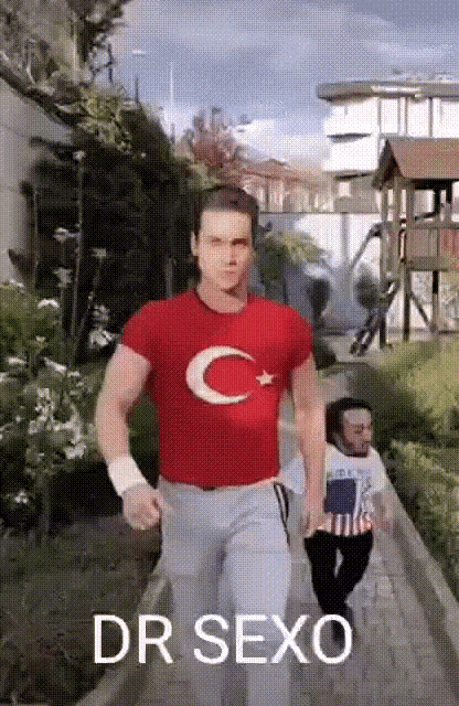 a man in a red shirt with a crescent moon on it is running down a sidewalk