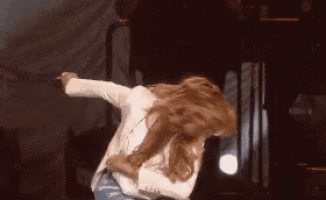 a woman is dancing on a stage in front of a microphone .