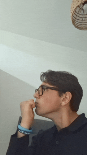 a young man wearing glasses and a bracelet that says a.s.d. camp