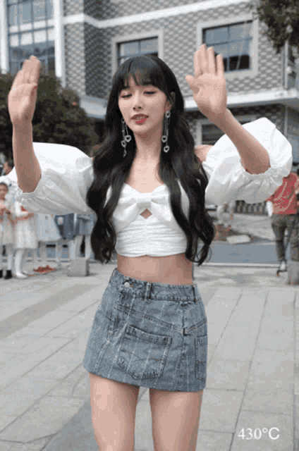 a woman in a white crop top and denim skirt is wearing a temperature of 430