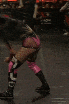 a female wrestler is kneeling down in a wrestling ring