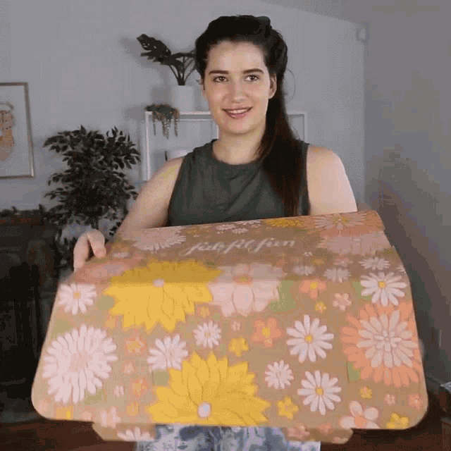 a woman holding a box with flowers on it that says josephin
