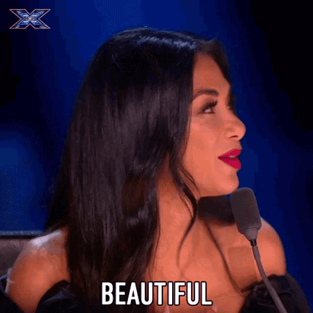 a woman sitting in front of a microphone with the word beautiful written on the screen