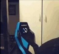 a person is sitting in a blue gaming chair in front of a closet .