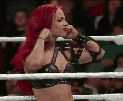 a woman with red hair is in a wrestling ring .