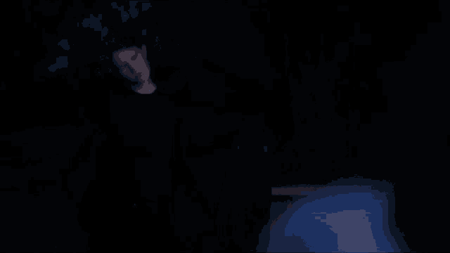 a woman in a black nike shirt is smiling in the dark