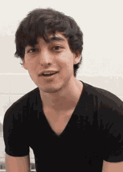 a young man in a black t-shirt is making a funny face .