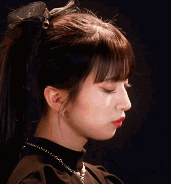 a woman with a bow in her hair is wearing a black top
