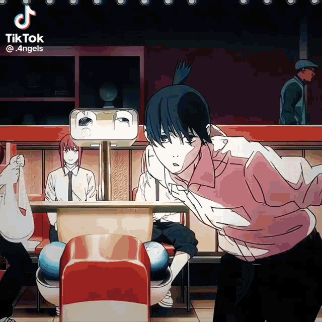 a man in a pink shirt is playing bowling in a restaurant