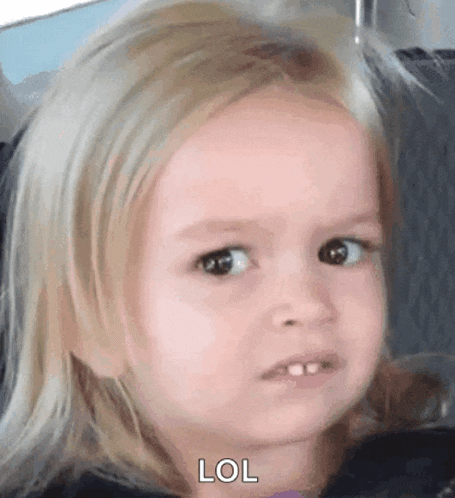 a little girl with blonde hair is making a funny face and saying lol .