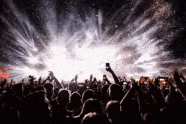 a crowd of people at a concert with their hands up
