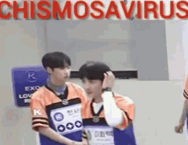 a couple of men standing next to each other in front of a sign that says chismosaurus .