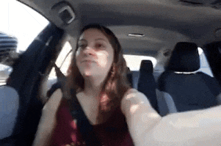 a woman is taking a selfie while sitting in a car