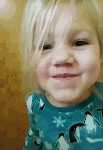 a little girl wearing a blue shirt with penguins on it smiles for the camera