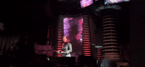 a woman is standing in front of a screen that says " silence creature "