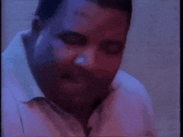a man with a beard and a white shirt is looking down