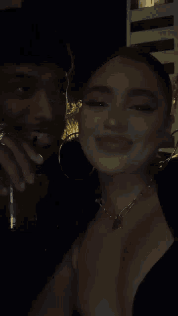a man and a woman are standing next to each other in the dark .