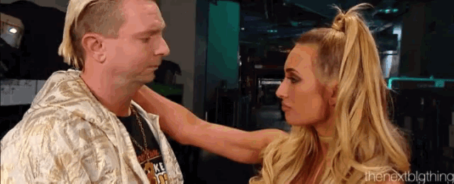 a man and a woman are looking into each other 's eyes and the woman is holding the man 's arm .
