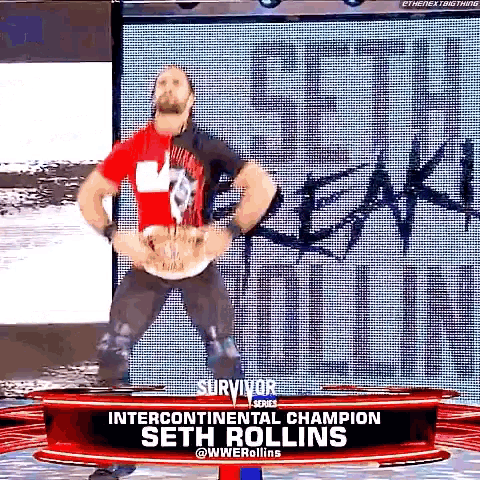 a man in a red shirt is standing in front of a sign that says ' survivor series ' on it .