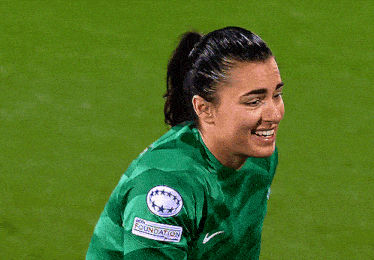 a female soccer player wearing a green nike jersey