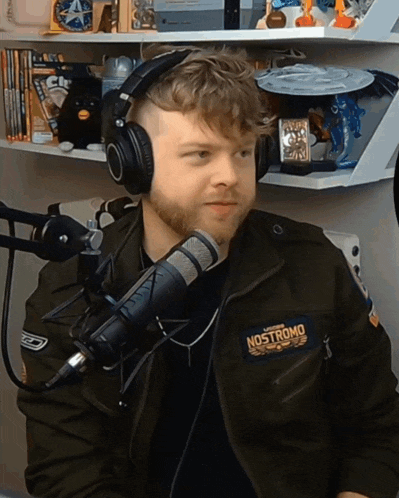 a man wearing headphones and a jacket that says " nostromo "